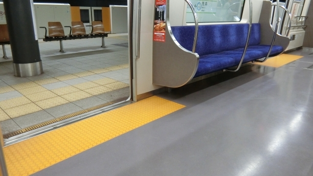 地下鉄の駅のホームと電車の車内の様子。黄色い点字ブロックが見える。