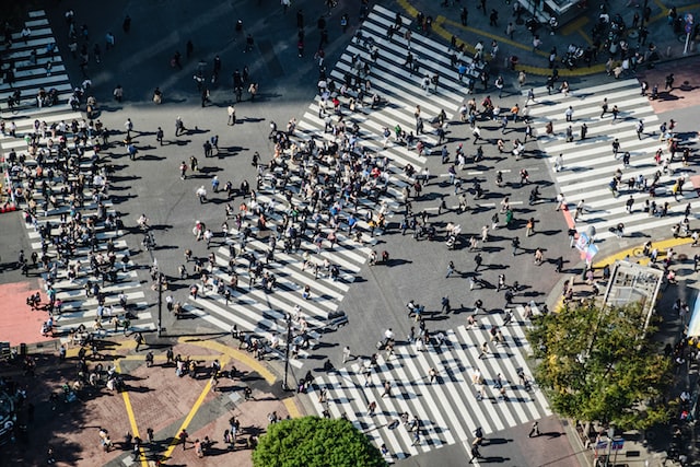 交差点を行き交う多くの人々を上空から撮影した写真。





