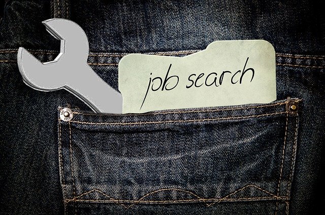 ジーンズのポケットに「job search」と書かれたメモとスパナが入っている画像。