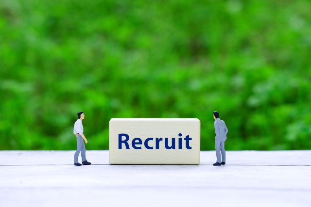 「Recruit」と書かれたブロックの前に立つ二人の男性のフィギュア