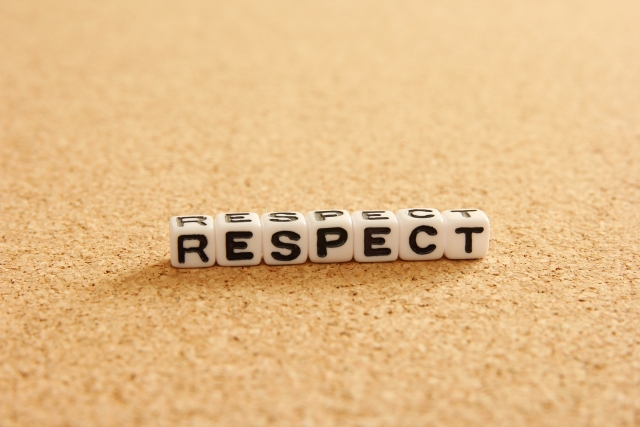 コルクボードの上に「RESPECT」と書かれた白いキューブブロック