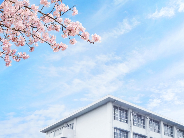 学校の校舎と青い空と桜