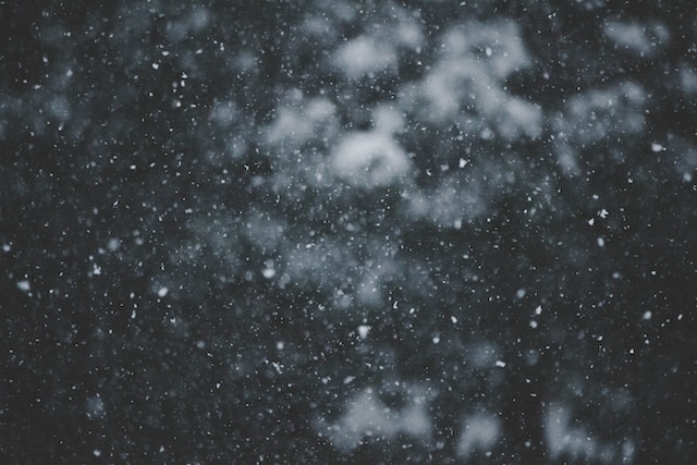 暗い背景に雪が舞う様子。ブログ「インナーチャイルドは3人いた！“あの頃の私”に出会って見つけた『自分の本音』」に関連する画像。