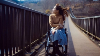 吊り橋を渡る車椅子の女性