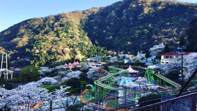 遠くから撮った遊園地と山のイメージ