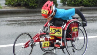 大分国際車いすマラソンで豆塚さんが雨の中必死で走っているイメージ