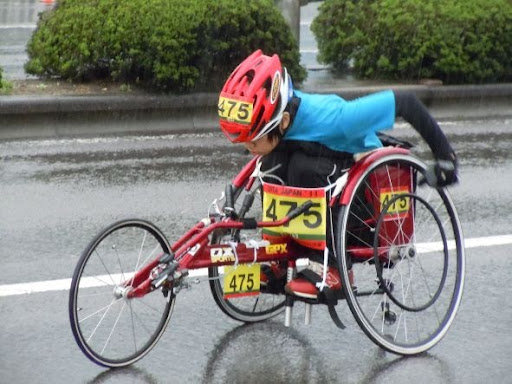 大分国際車いすマラソンで豆塚さんが雨の中必死で走っているイメージ