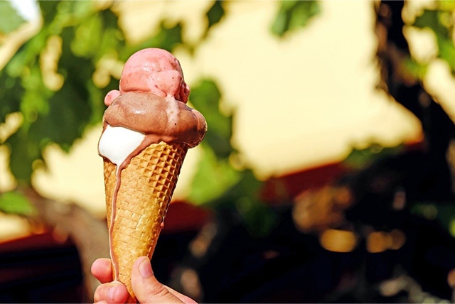 暑い夏に溶け始めたアイスクリームを手に持っている様子。